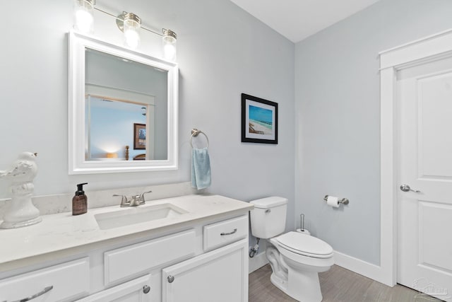 bathroom with vanity, hardwood / wood-style floors, and toilet