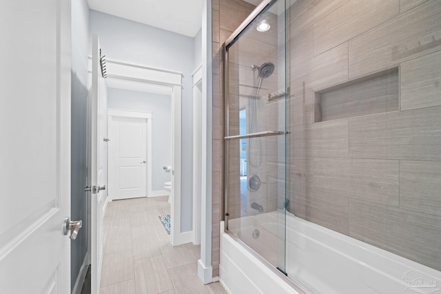 bathroom with enclosed tub / shower combo and toilet