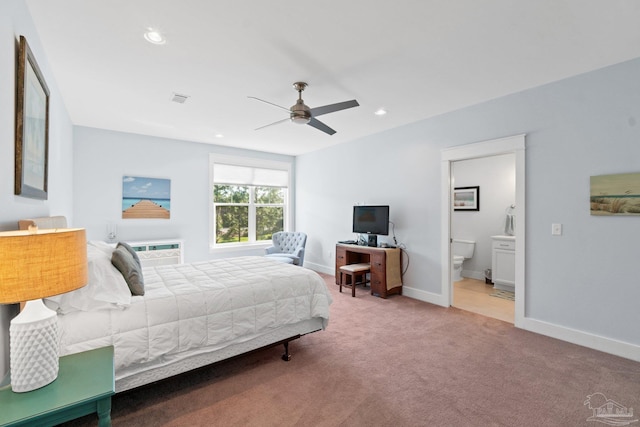 carpeted bedroom featuring ceiling fan, ensuite bath, and a wall unit AC