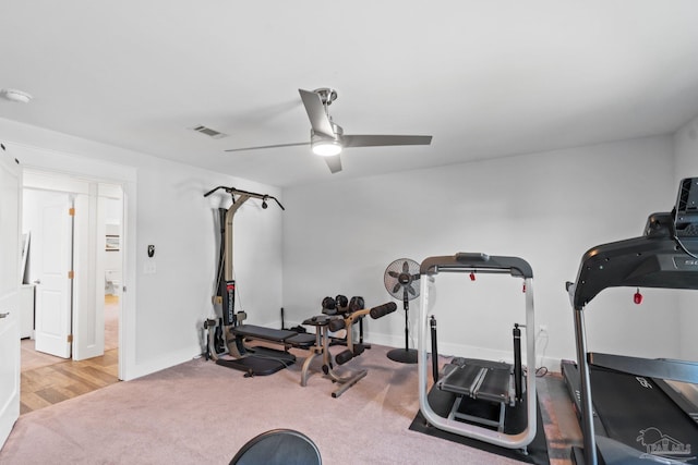 workout room with ceiling fan and light colored carpet