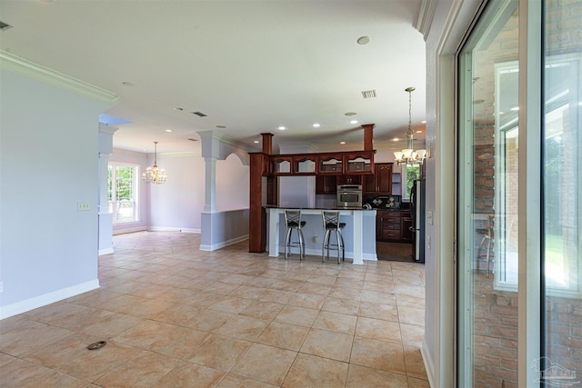 kitchen featuring decorative light fixtures, ornamental molding, a chandelier, and stainless steel appliances