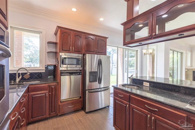 kitchen with a healthy amount of sunlight, appliances with stainless steel finishes, sink, and decorative backsplash