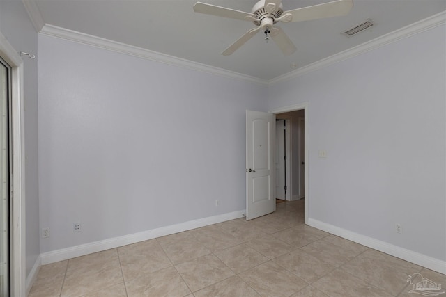 spare room with ceiling fan, ornamental molding, and light tile patterned floors