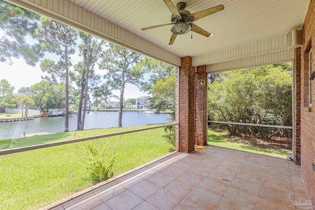 unfurnished sunroom with a water view and ceiling fan