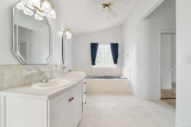 bathroom with vanity, tiled bath, backsplash, lofted ceiling, and ceiling fan