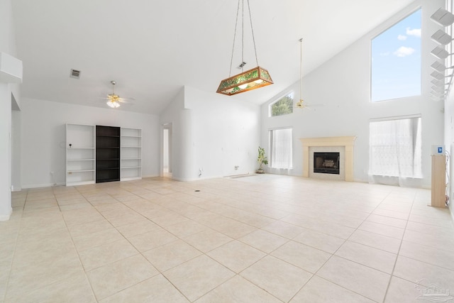 unfurnished living room with a fireplace, high vaulted ceiling, built in shelves, light tile patterned floors, and ceiling fan