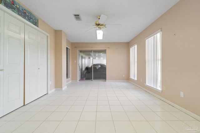 interior space with light tile patterned flooring and ceiling fan