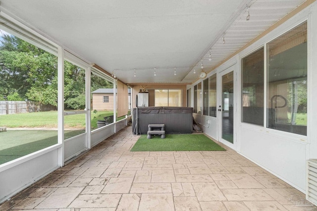 unfurnished sunroom with plenty of natural light and track lighting