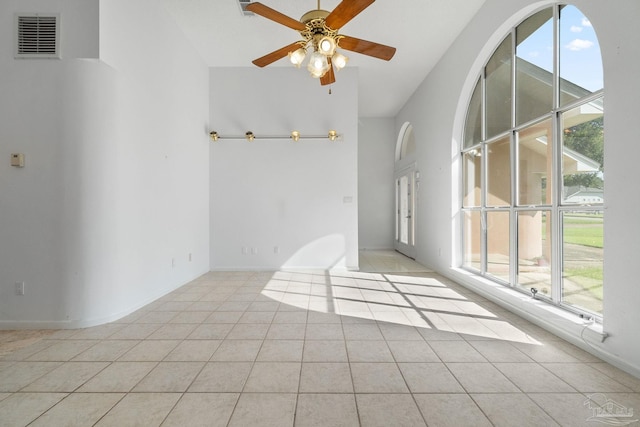 tiled empty room with a healthy amount of sunlight and ceiling fan