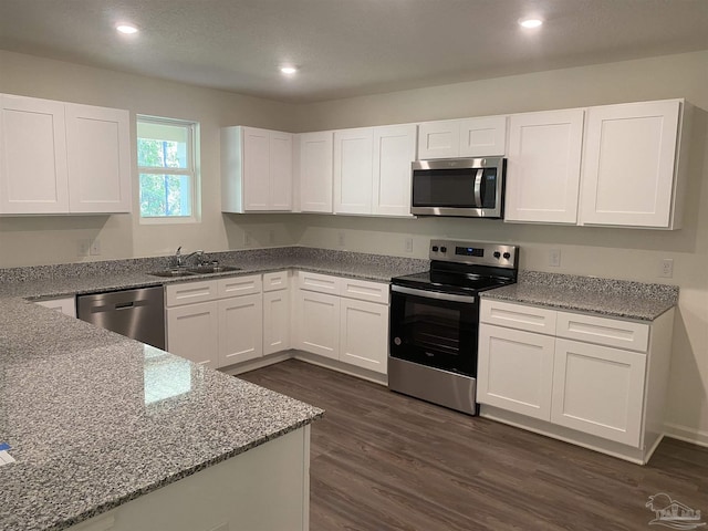 kitchen featuring stainless steel appliances, white cabinets, sink, and light stone counters