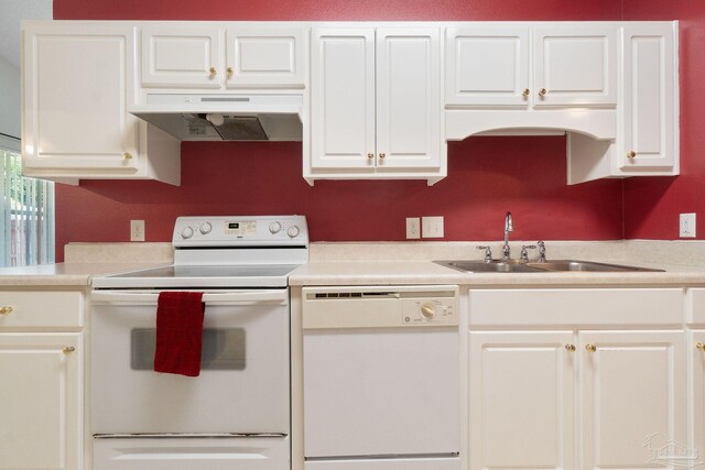 kitchen featuring white cabinets, wall chimney range hood, and white appliances