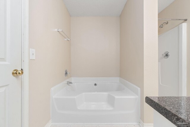 bathroom featuring a textured ceiling and a bathing tub