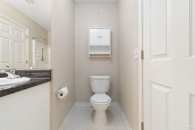 bathroom featuring tile patterned floors, toilet, and vanity