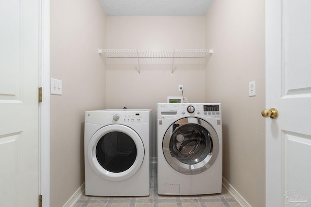 washroom with light tile patterned flooring and washer and dryer