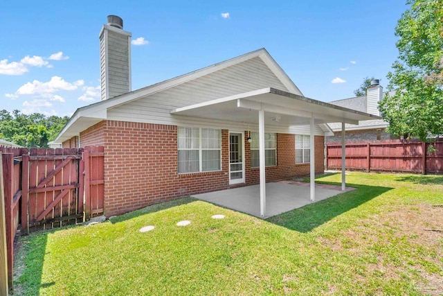 back of property with a patio and a lawn