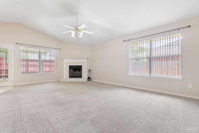 unfurnished living room featuring a fireplace, a wealth of natural light, lofted ceiling, and carpet flooring