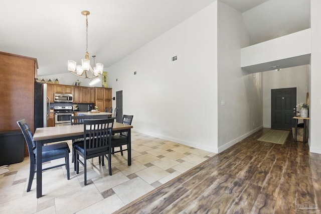 4793 Coronado Cir, Crestview, FL 32539 - dining room featuring high vaulted ceiling, a chandelier, baseboards, and light wood-style flooring