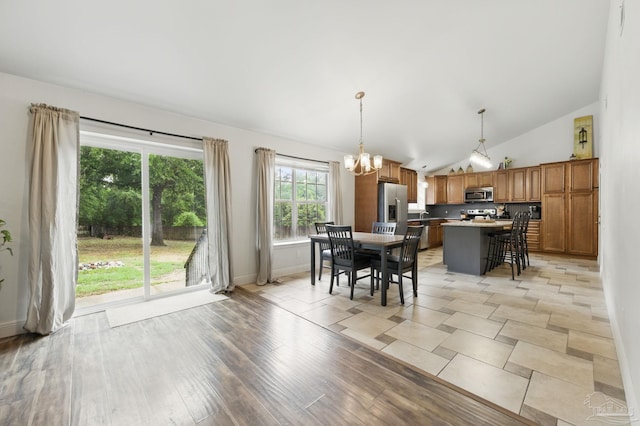 4793 Coronado Cir, Crestview, FL 32539 - dining area featuring a chandelier, vaulted ceiling, baseboards, and light wood-style flooring