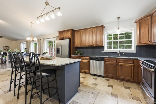 4793 Coronado Cir, Crestview, FL 32539 - kitchen featuring stainless steel appliances, a sink, backsplash, a chandelier, and light stone counters