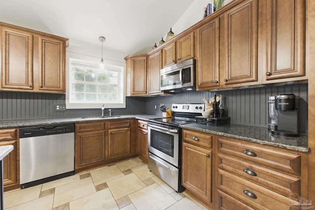 4793 Coronado Cir, Crestview, FL 32539 - kitchen featuring stainless steel appliances, a sink, brown cabinets, and pendant lighting