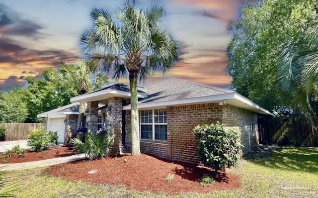 view of front of property with concrete driveway, an attached garage, fence, brick siding, and a front lawn