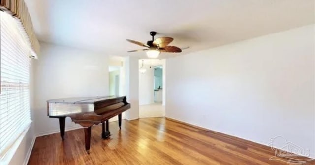 living area featuring a ceiling fan and light wood finished floors