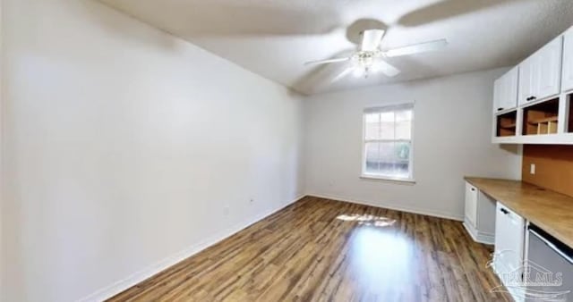 unfurnished dining area featuring baseboards, wood finished floors, and ceiling fan