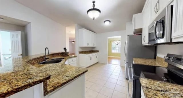 kitchen featuring white cabinetry, a sink, stainless steel appliances, and light stone countertops