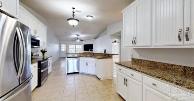 kitchen with white cabinetry, lofted ceiling, light tile patterned floors, stainless steel appliances, and ceiling fan