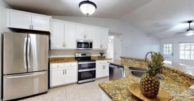 kitchen with white cabinetry, vaulted ceiling, a sink, a ceiling fan, and appliances with stainless steel finishes
