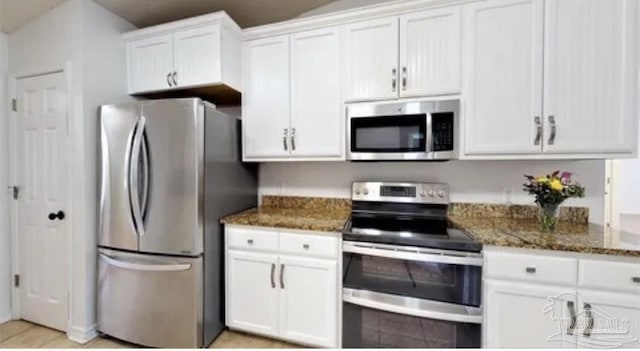 kitchen with white cabinetry, dark stone counters, and appliances with stainless steel finishes