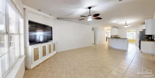unfurnished living room featuring light tile patterned floors and a ceiling fan