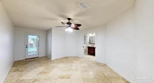 empty room featuring visible vents and ceiling fan