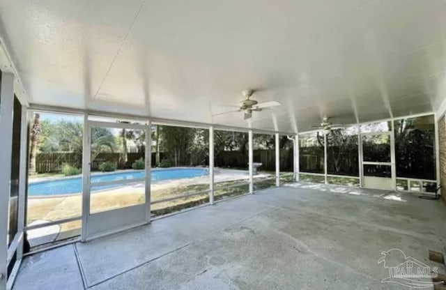unfurnished sunroom with ceiling fan
