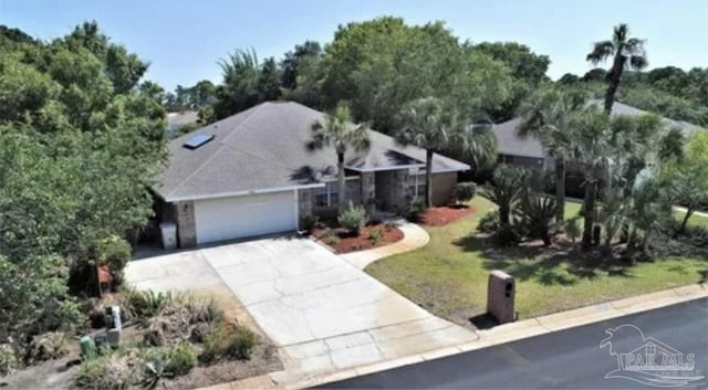 view of front of property featuring a front yard, a garage, and concrete driveway