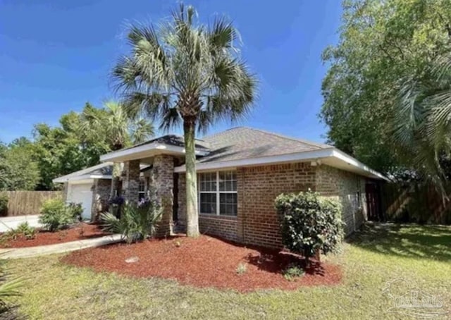 ranch-style house with brick siding, a front lawn, fence, and an attached garage