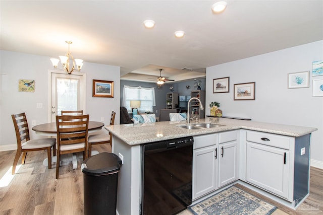 kitchen featuring light wood-type flooring, sink, white cabinetry, black dishwasher, and ceiling fan with notable chandelier