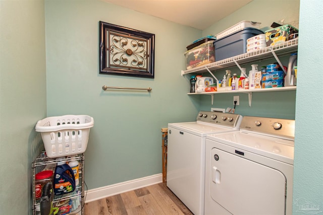 clothes washing area with light hardwood / wood-style floors and washing machine and dryer