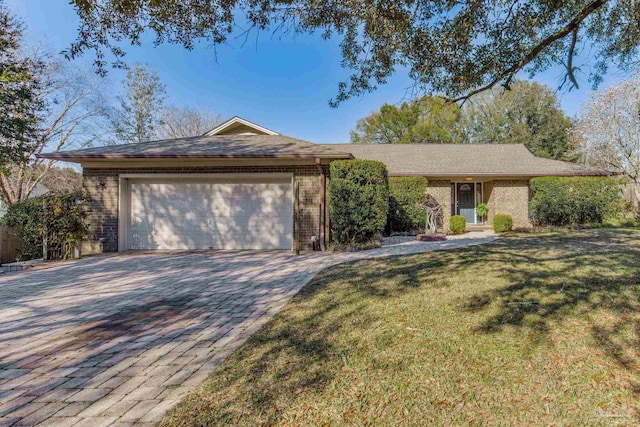 ranch-style house featuring a front lawn, decorative driveway, brick siding, and an attached garage