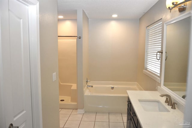 1701 Eagle Ter, Cantonment, FL 32533 - bathroom with tile patterned flooring, a garden tub, vanity, a textured ceiling, and a stall shower