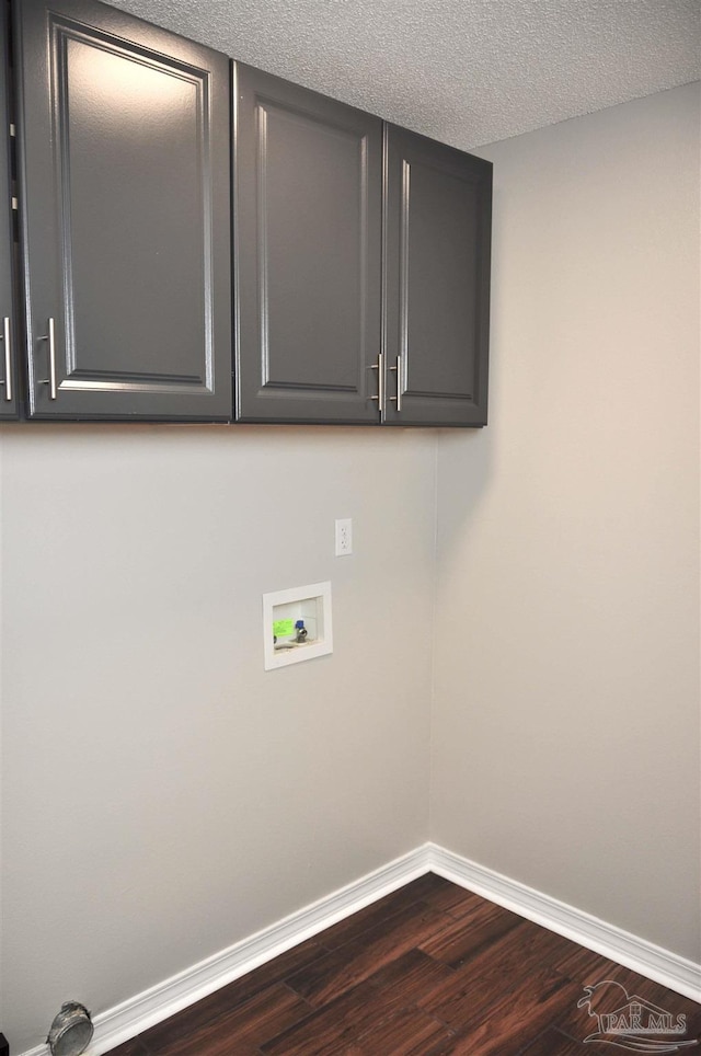 1701 Eagle Ter, Cantonment, FL 32533 - washroom featuring baseboards, washer hookup, dark wood-style flooring, and cabinet space
