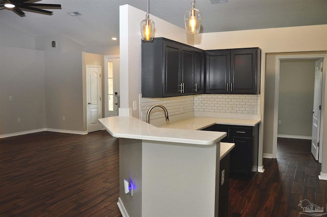1701 Eagle Ter, Cantonment, FL 32533 - kitchen featuring ceiling fan, backsplash, dark wood finished floors, light countertops, and a peninsula