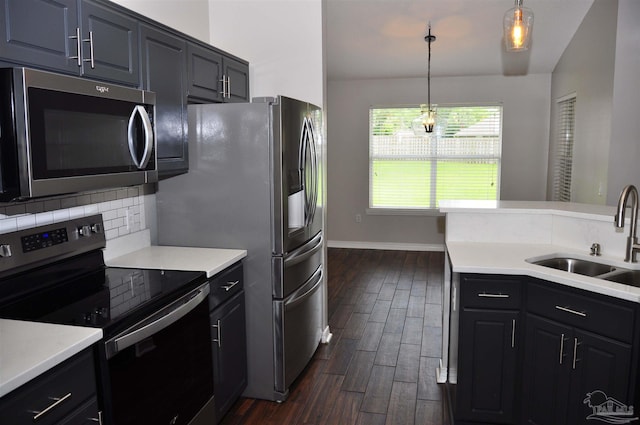 1701 Eagle Ter, Cantonment, FL 32533 - kitchen featuring dark wood-style flooring, a sink, light countertops, stainless steel appliances, and decorative backsplash