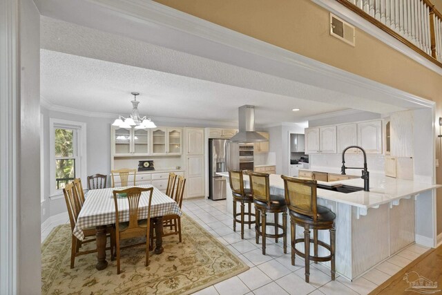 dining space featuring a textured ceiling, light tile patterned floors, crown molding, and an inviting chandelier