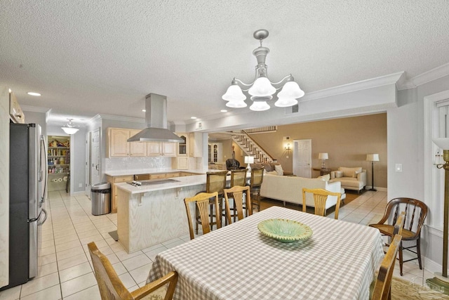 tiled dining area with a textured ceiling, ornamental molding, and an inviting chandelier