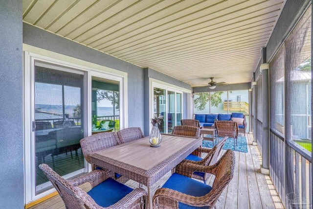 sunroom / solarium with ceiling fan, a water view, and plenty of natural light