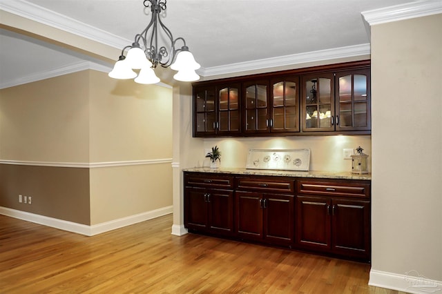 bar with light stone counters, crown molding, decorative light fixtures, a chandelier, and light hardwood / wood-style floors