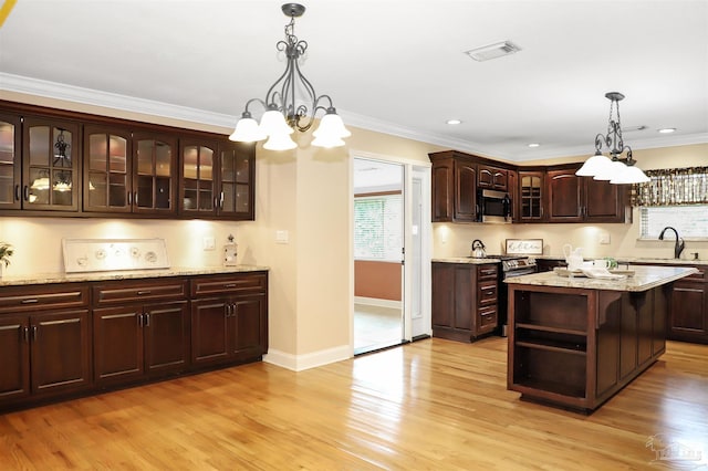 kitchen featuring stainless steel appliances, a center island, dark brown cabinetry, and decorative light fixtures