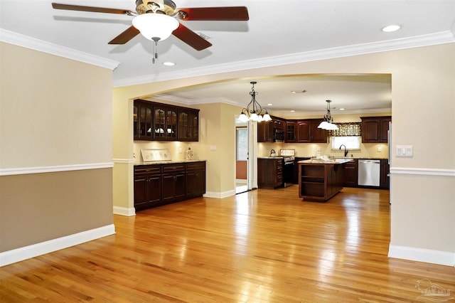 kitchen with dark brown cabinetry, decorative light fixtures, appliances with stainless steel finishes, a kitchen island, and light hardwood / wood-style floors