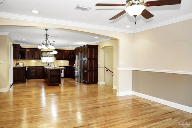 kitchen with pendant lighting, a center island, dark brown cabinetry, high end fridge, and light wood-type flooring